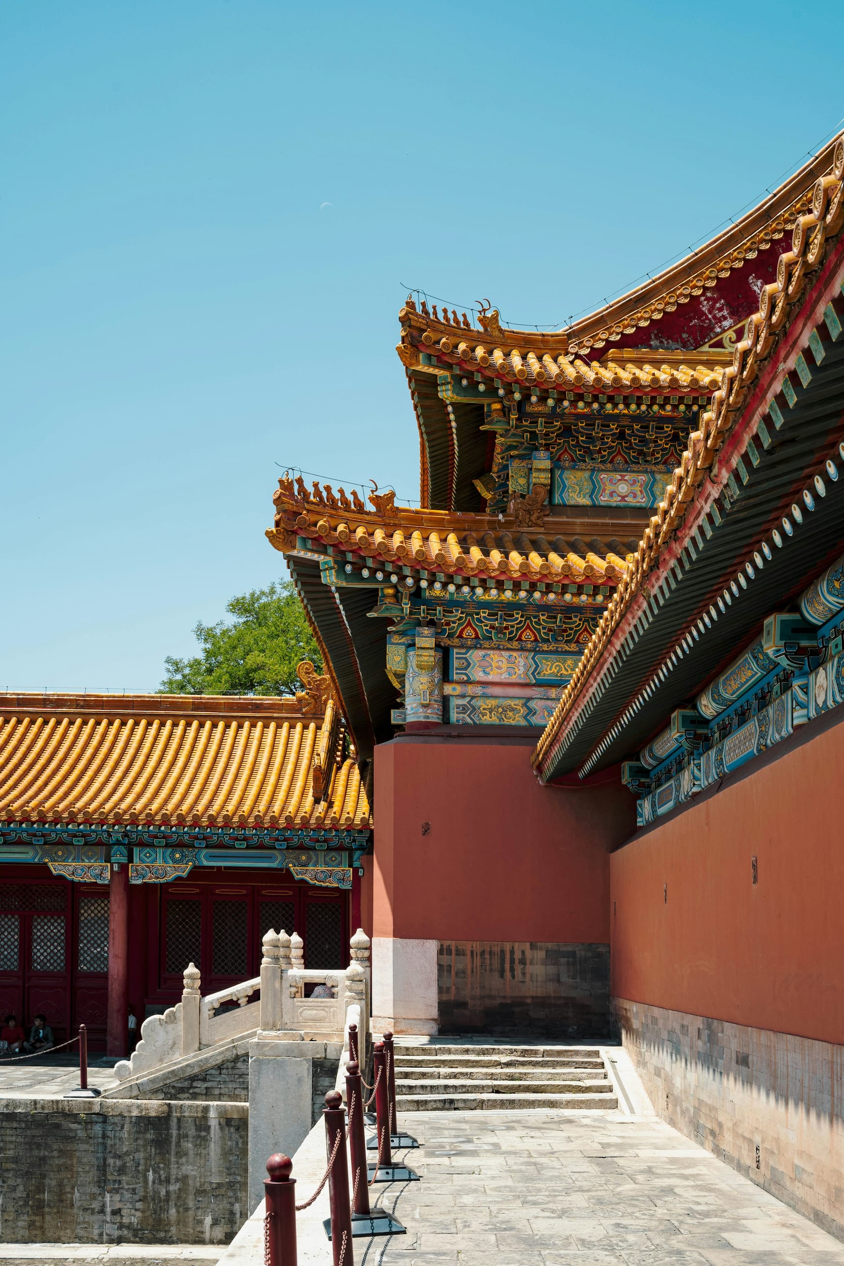 Red walls and ornate yellow-tiled roofs of Beijing's Forbidden City under a clear sky