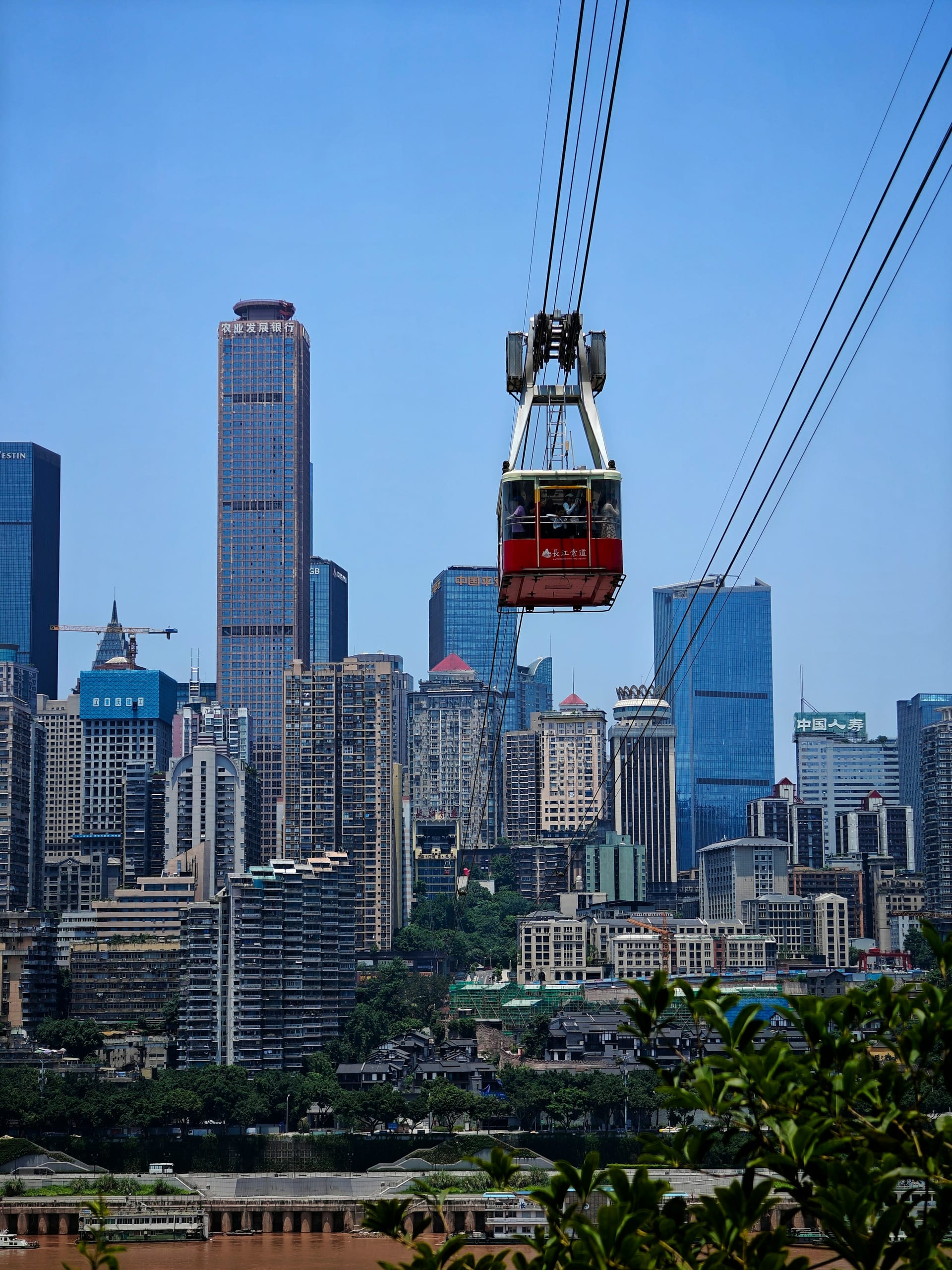 Yangtze River Cableway cabin crossing above the river with Chongqing skyscrapers in the background