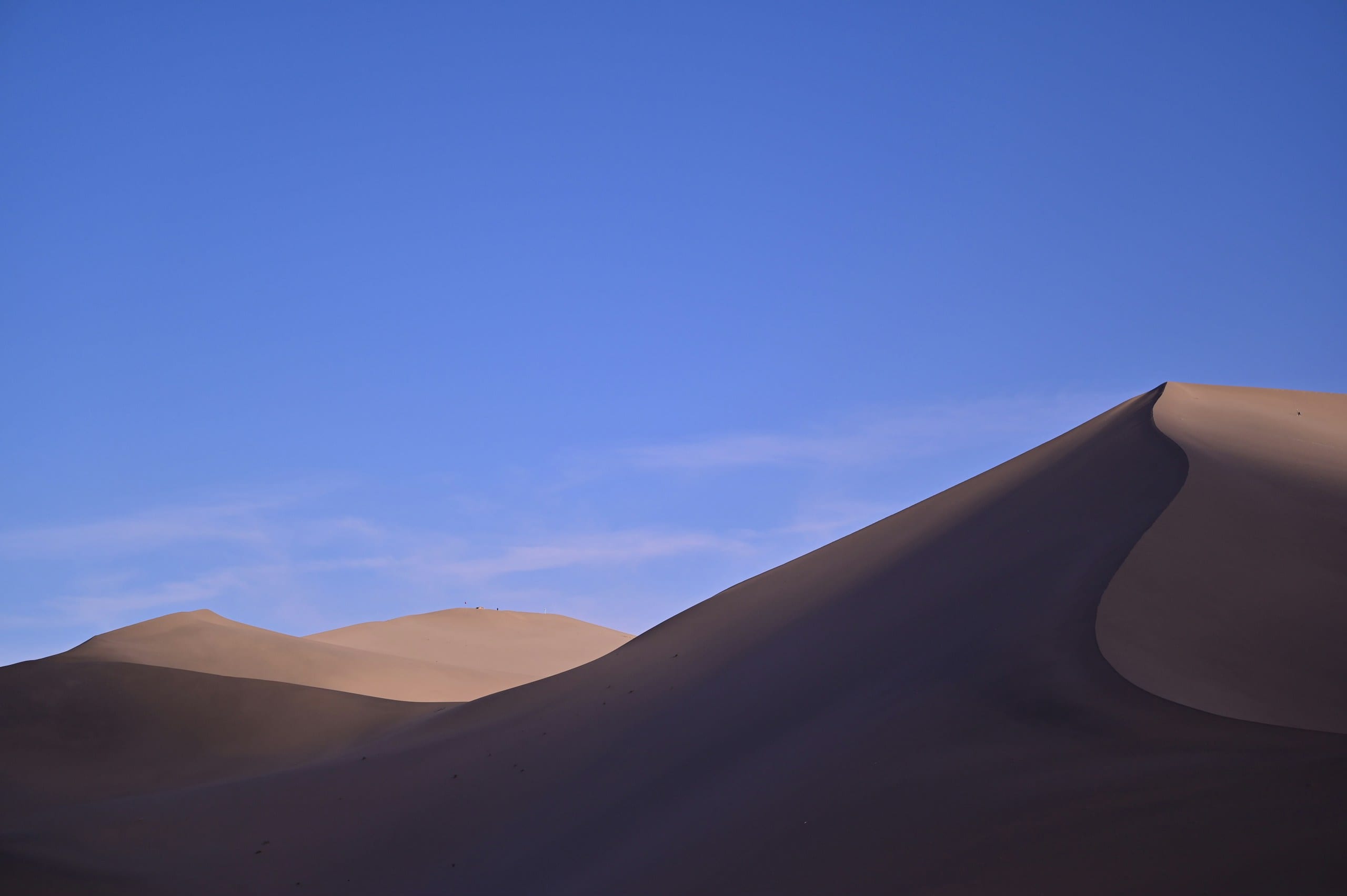 Sand dunes under a clear blue sky at Mingsha Mountain near Dunhuang in Gansu