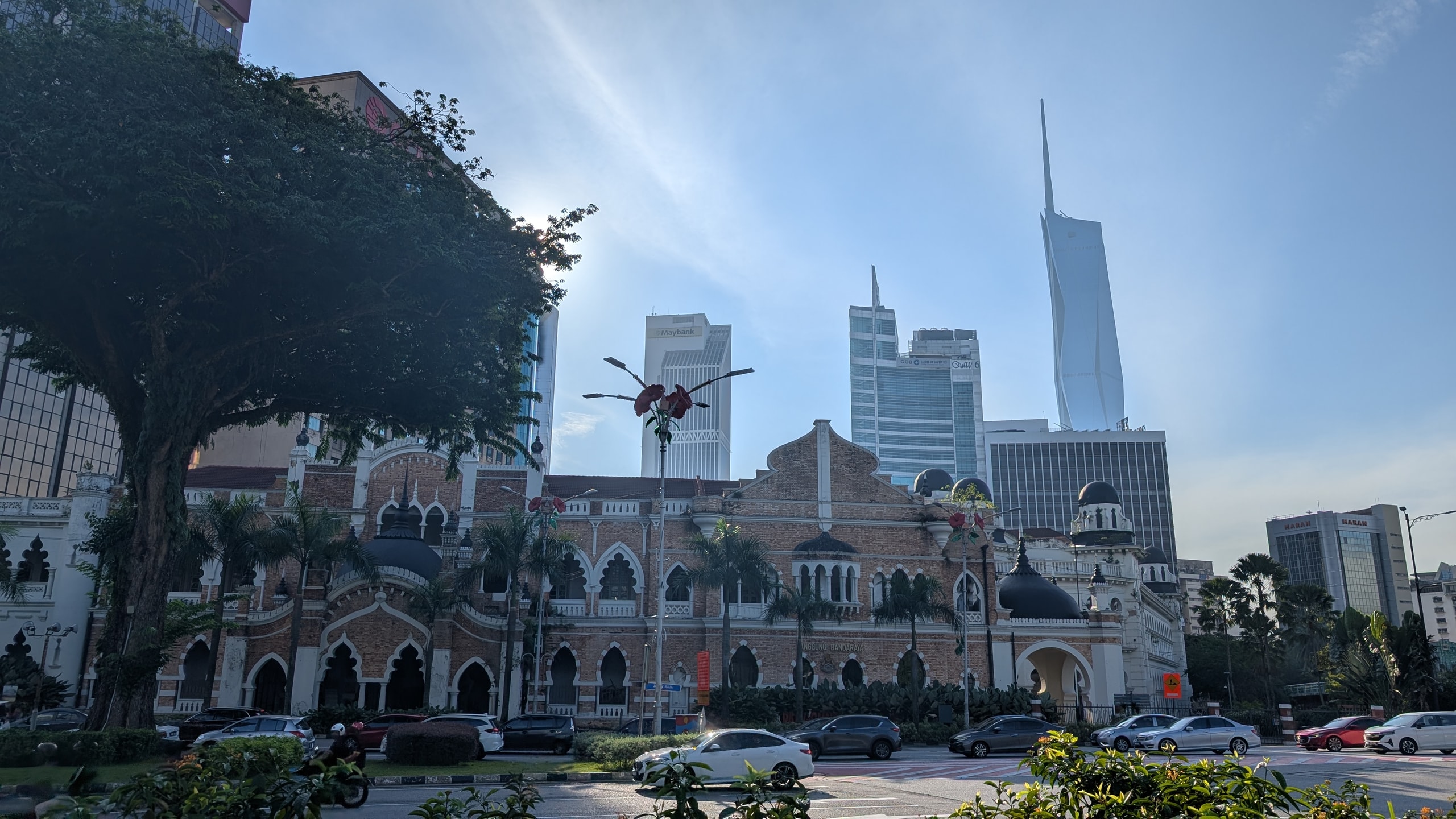The red-brick Moorish-style Panggung Bandaraya on Jalan Raja with arched windows and dark domes, the Maybank tower and the pale spire of Merdeka 118 rising behind it