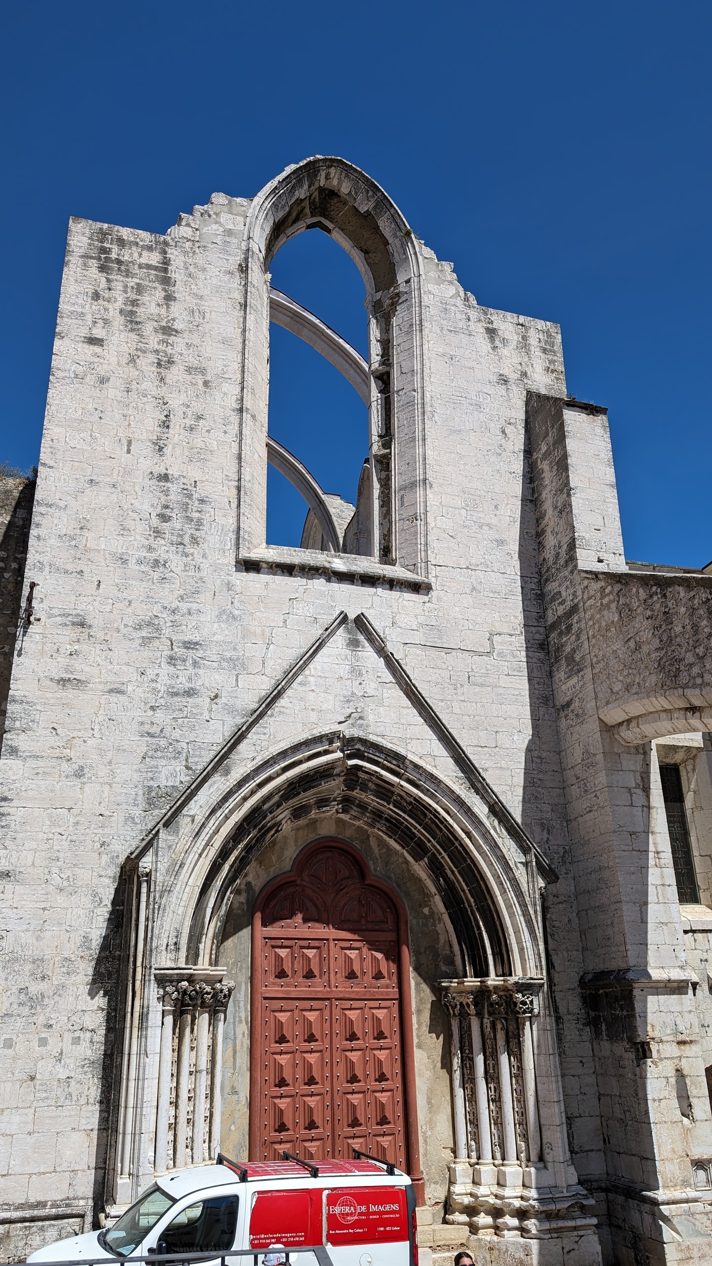 The roofless Gothic portal of Convento do Carmo, with carved stone arches open to a deep blue sky