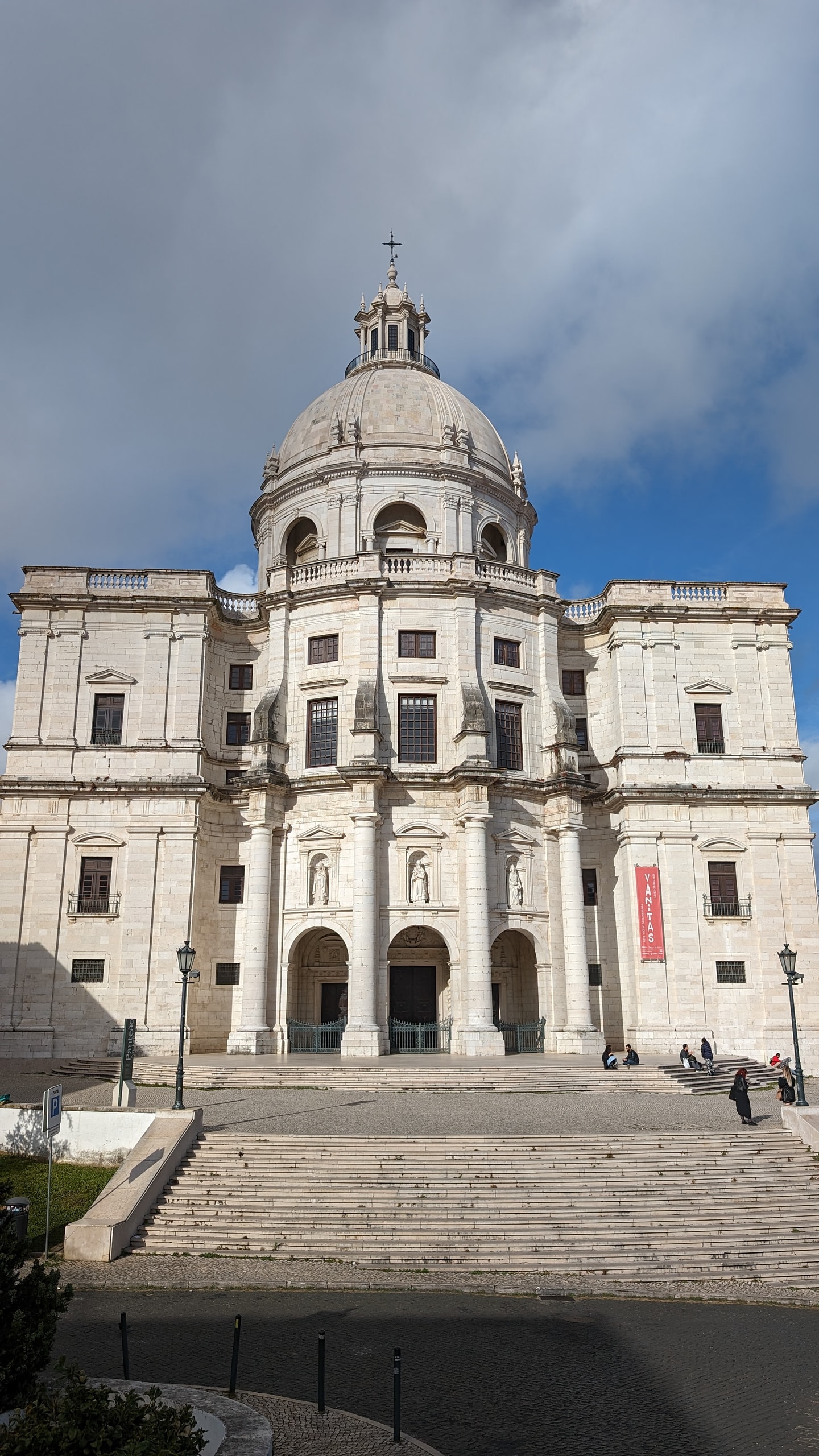The white limestone dome and Baroque facade of Lisbon’s National Pantheon, with statues in niches and a red exhibition banner on the right