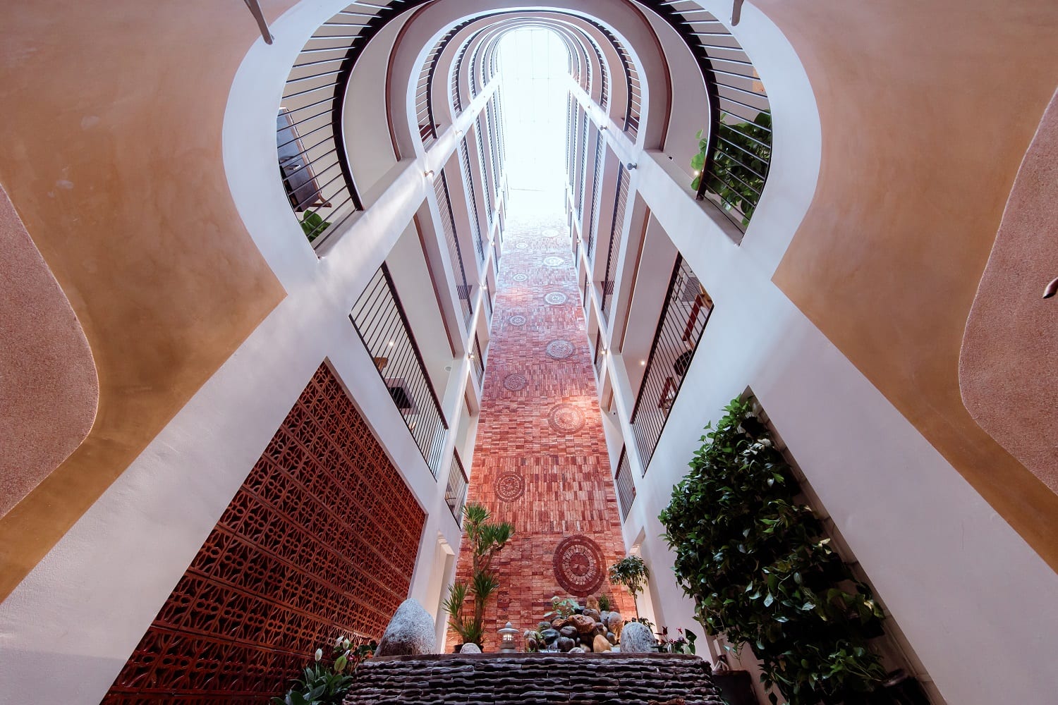 Little Gem Hoi An atrium with koi pond, tropical plants, and multi-level balconies around the courtyard