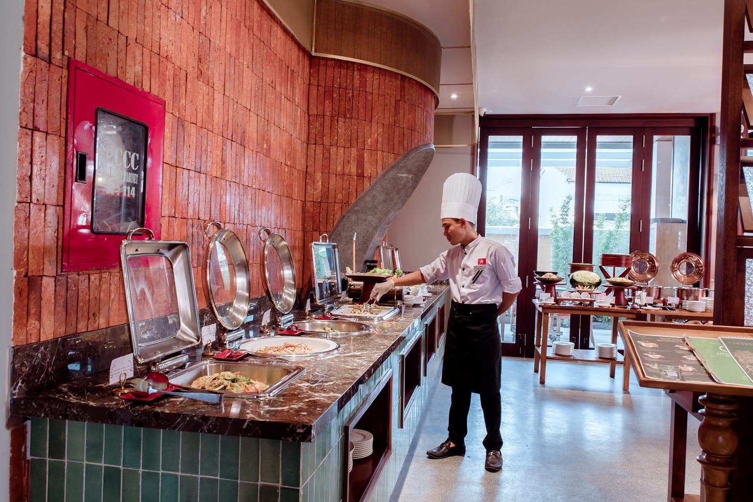 Breakfast buffet spread at HERB restaurant in Little Gem Hoi An with pastries, fruit, and hot dishes