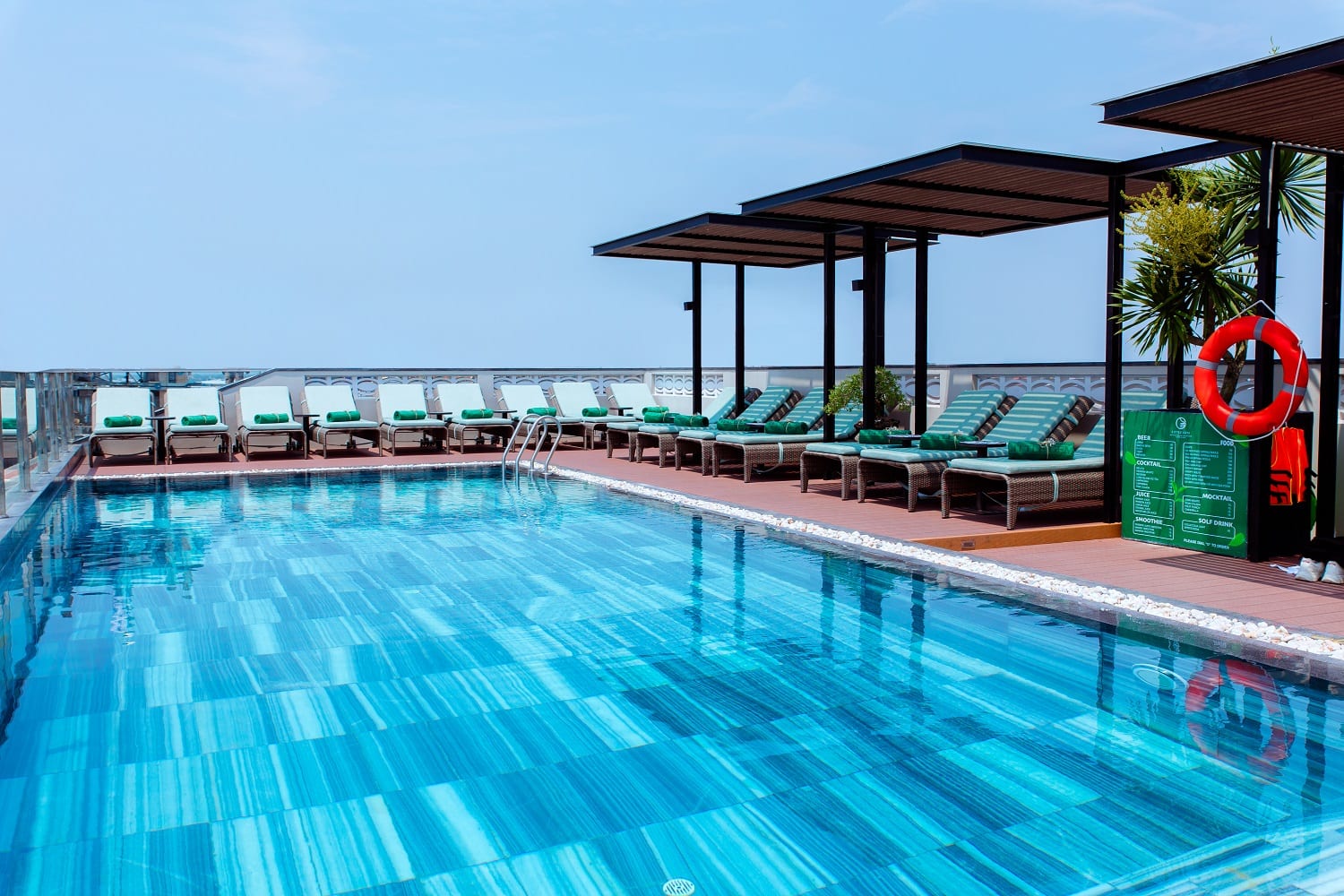 Rooftop pool at Little Gem Hoi An with sun loungers and umbrellas overlooking the river