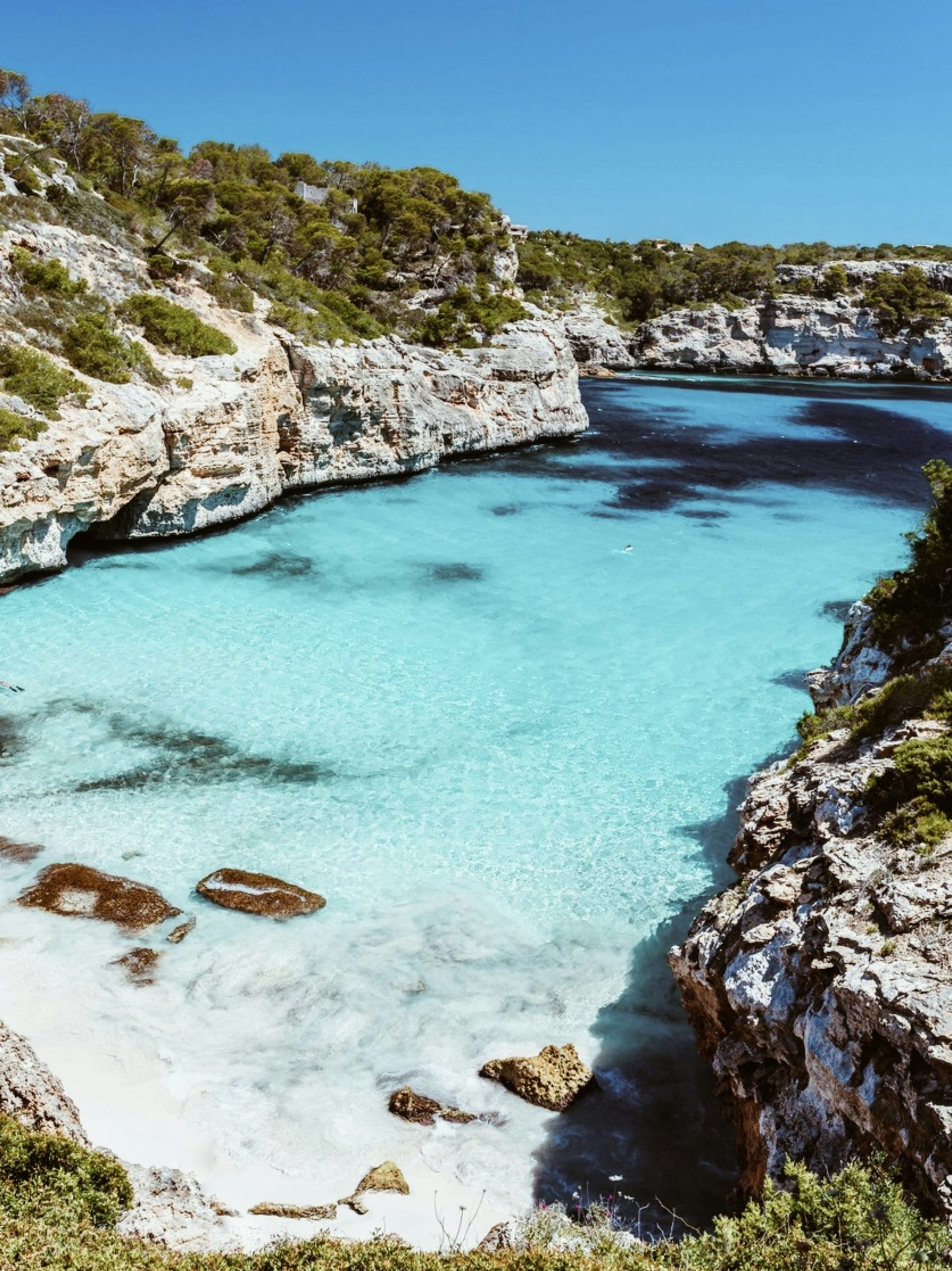Turquoise water and pale sand wedged between limestone cliffs at Cala des Moro on Mallorca