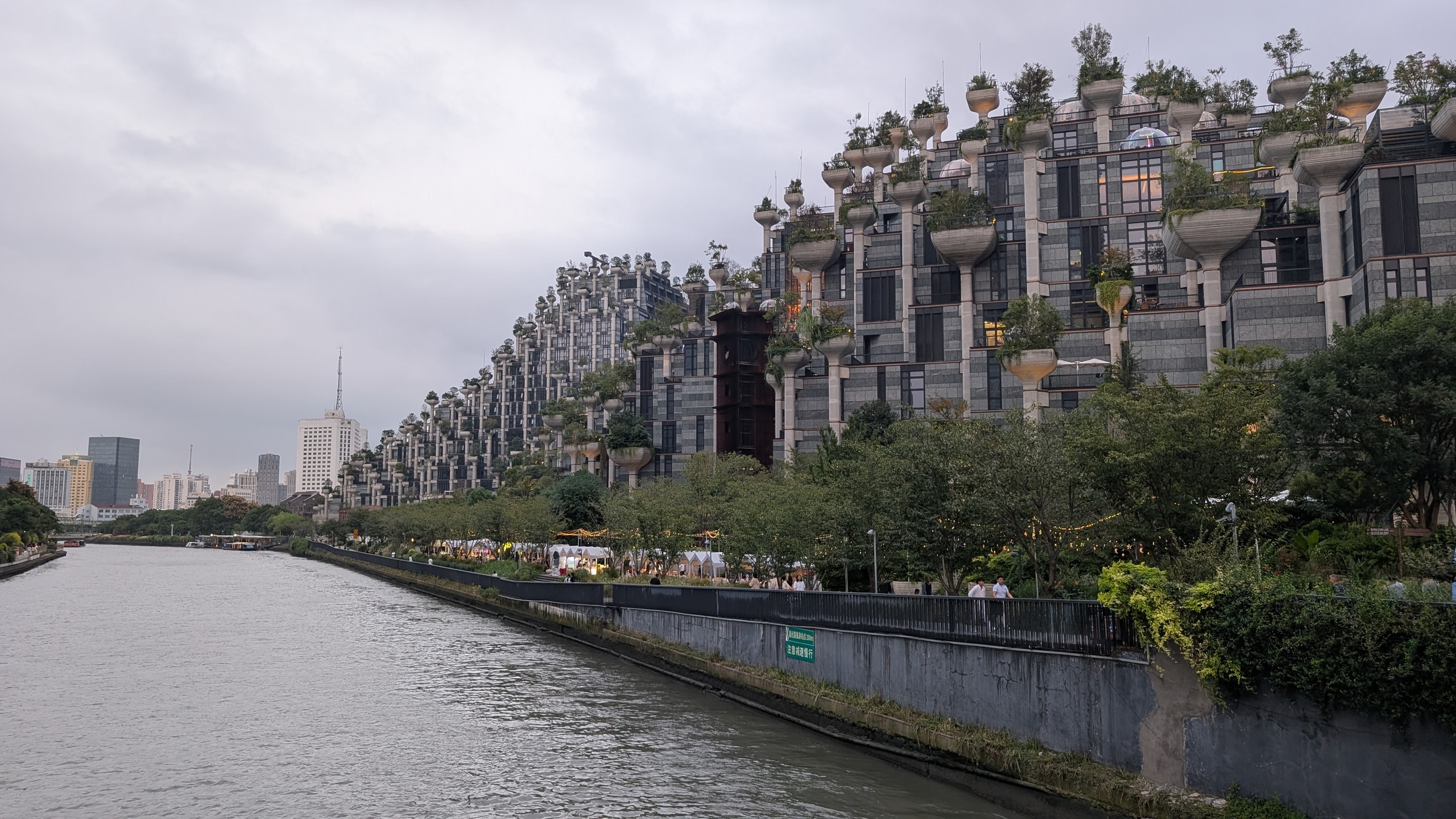 The 1000 Trees building on Suzhou Creek, a stepped concrete structure with trees planted on top of hundreds of columns
