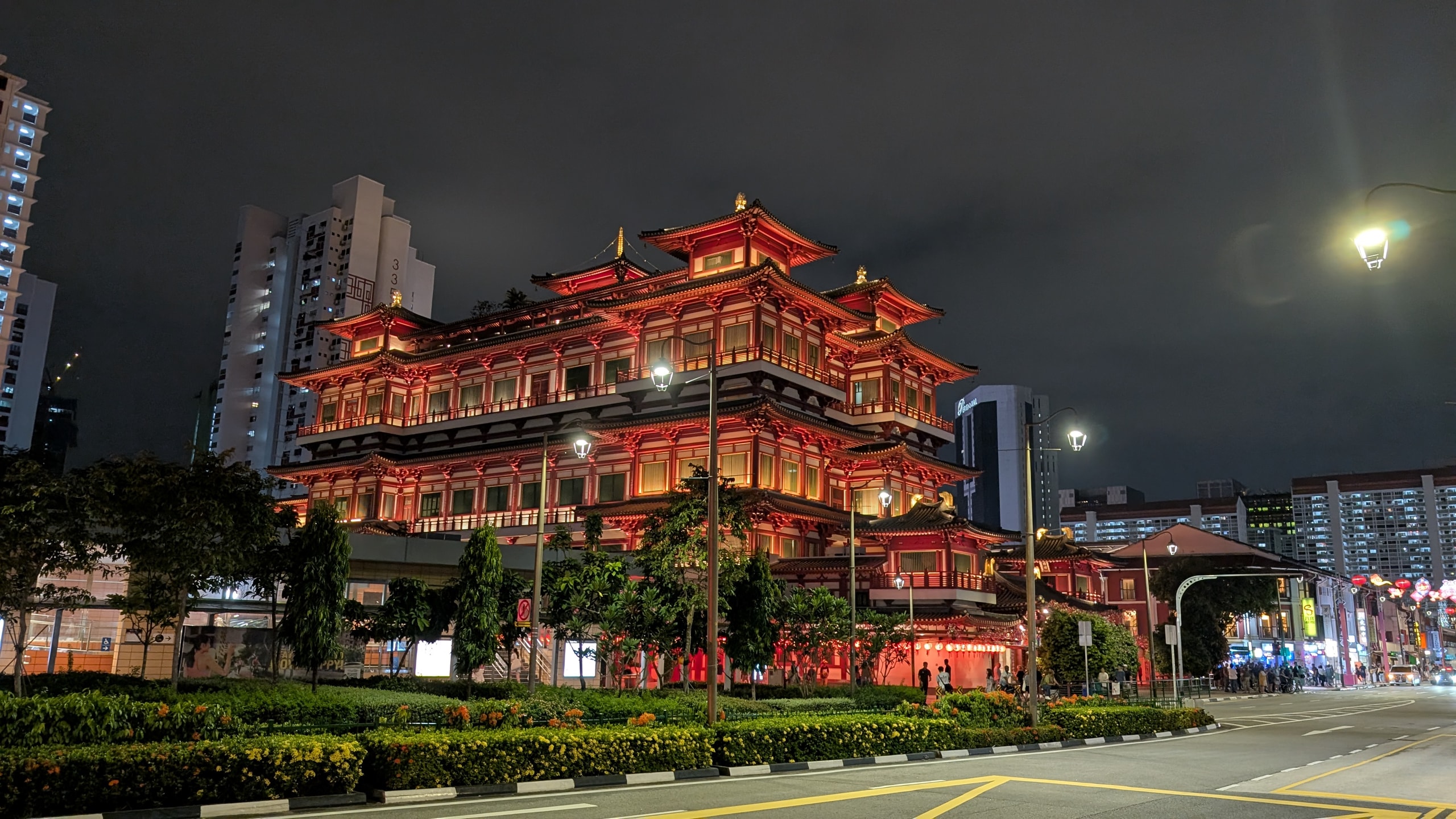The Buddha Tooth Relic Temple in Chinatown lit red and gold at night above an empty street