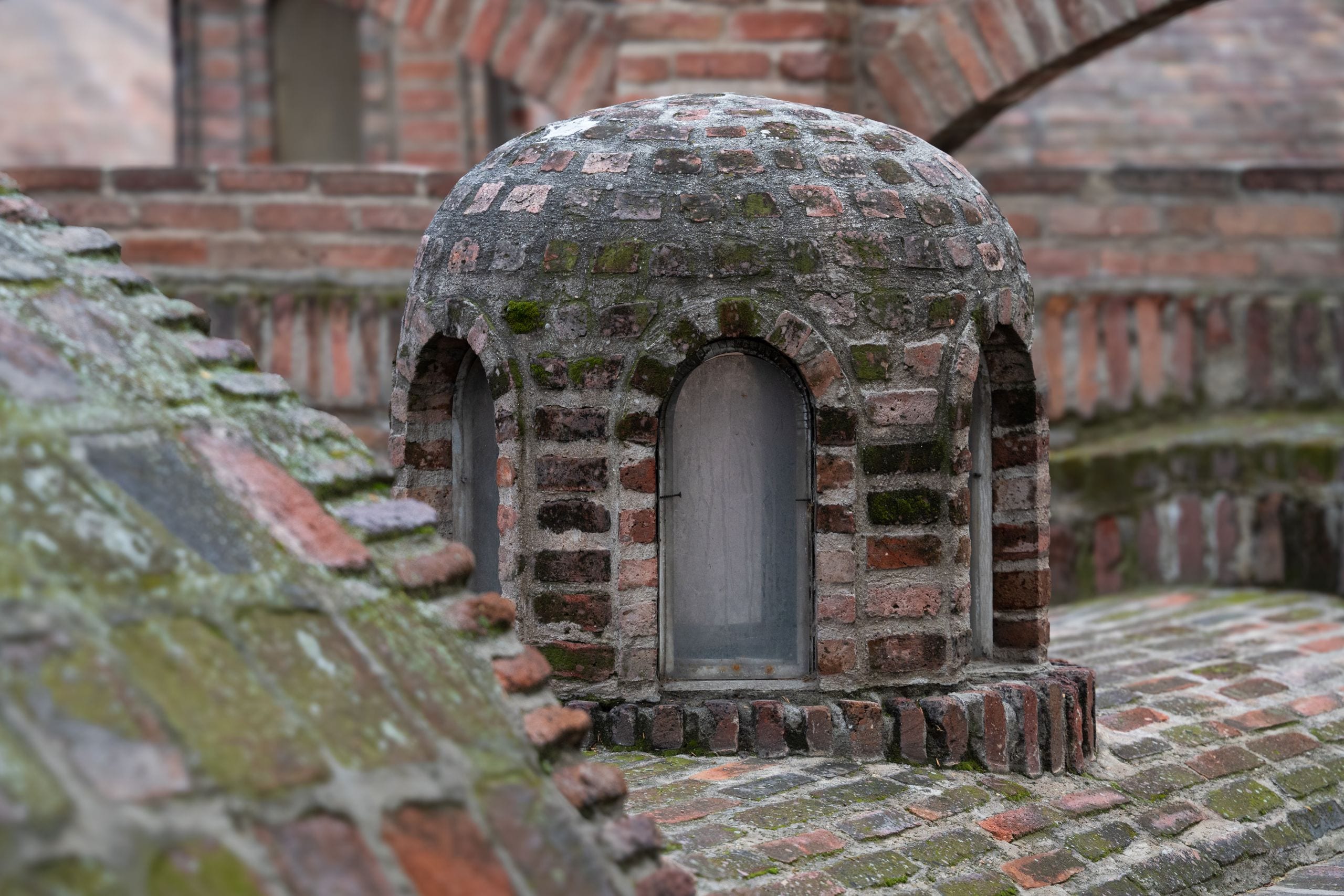 Weathered brick dome with arched windows on a sulfur bathhouse in Tbilisi's Abanotubani district
