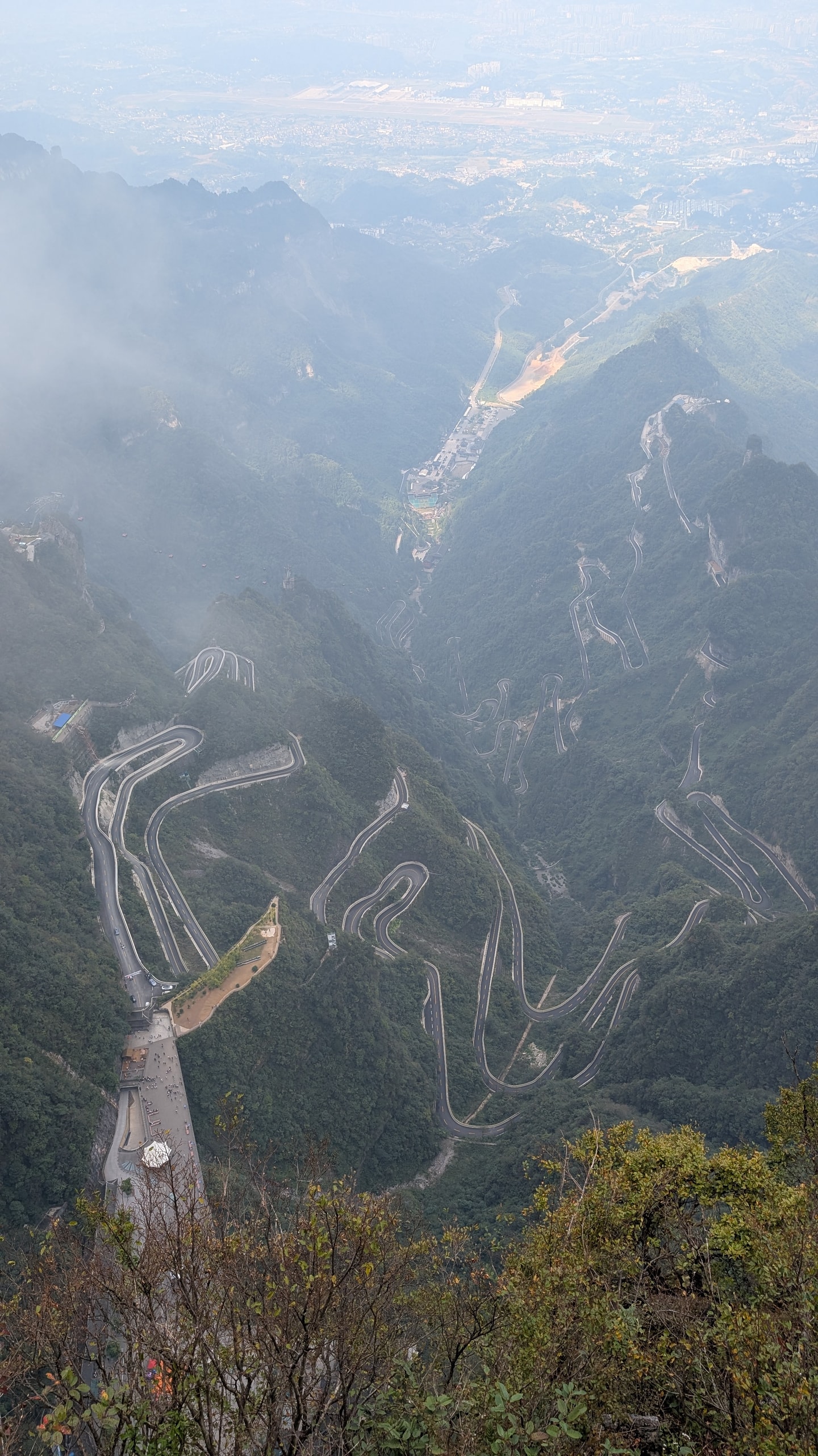 Aerial view of the 99 hairpin bends of Tongtian Avenue winding up a forested gorge below Tianmen Mountain