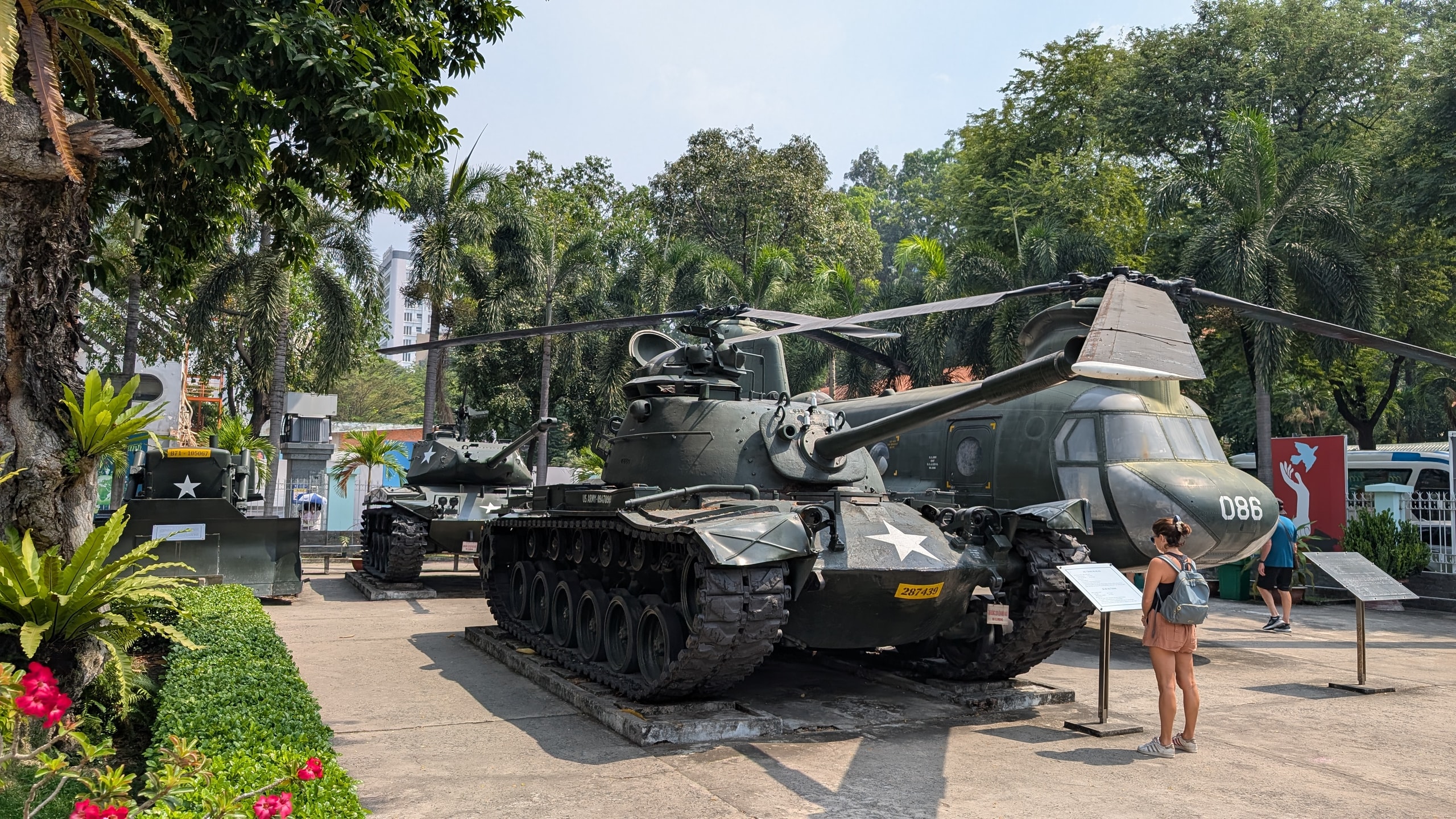 Olive-drab M48 tank and Chinook helicopter on display in the outdoor yard of the War Remnants Museum in Ho Chi Minh City