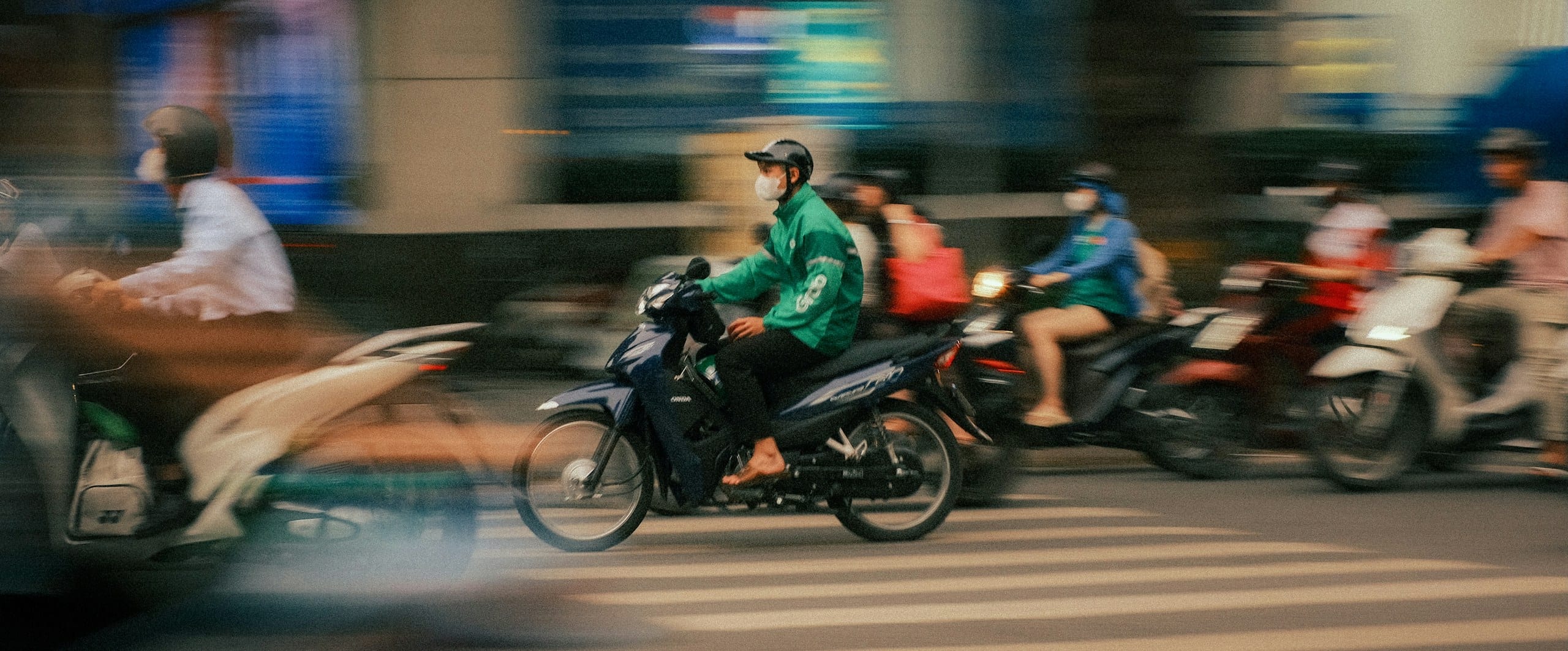A dense stream of motorbikes crossing a busy intersection in Hanoi